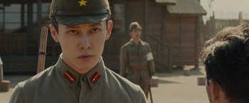 Movie still from “Unbroken” (2014), directed by Angelina Jolie – A man in a military uniform stands in front of another man in a uniform; Close Up shot, Low angle