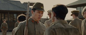 Movie still from “Unbroken” (2014), directed by Angelina Jolie – A man in a military uniform talking to another man in a military uniform; Close Up shot, Over the shoulder angle