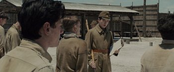 Movie still from “Unbroken” (2014), directed by Angelina Jolie – A group of young men standing next to each other on a field; Medium shot, Over the shoulder angle