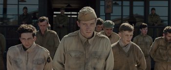 Movie still from “Unbroken” (2014), directed by Angelina Jolie – A group of men standing next to each other; Medium shot, Low angle