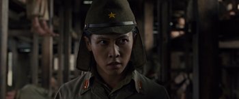 Movie still from “Unbroken” (2014), directed by Angelina Jolie – A man wearing a uniform and a hat; Close Up shot, Low angle