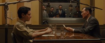 Movie still from “Unbroken” (2014), directed by Angelina Jolie – A group of people sitting at a table in front of a mirror; Medium shot, Over the shoulder angle