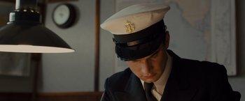 Movie still from “Unbroken” (2014), directed by Angelina Jolie – A man in a uniform is wearing a hat; Close Up shot, High angle