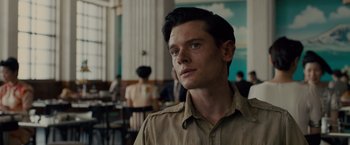 Movie still from “Unbroken” (2014), directed by Angelina Jolie – A man in a tan shirt is looking at the camera; Close Up shot, Over the shoulder angle