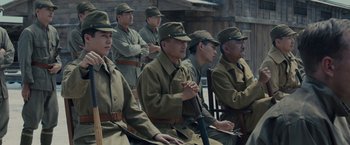Movie still from “Unbroken” (2014), directed by Angelina Jolie – A group of men in military uniforms sitting in a row; Medium shot, High angle