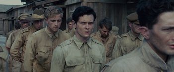 Movie still from “Unbroken” (2014), directed by Angelina Jolie – A group of men standing next to each other; Medium shot, Over the shoulder angle