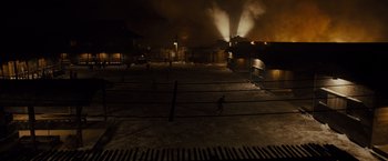 Movie still from “Unbroken” (2014), directed by Angelina Jolie – People are walking in a parking lot at night; Extreme Wide shot, High angle