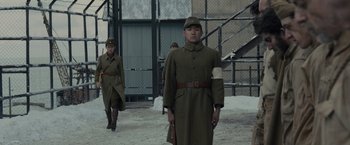 Movie still from “Unbroken” (2014), directed by Angelina Jolie – A group of men in military uniforms walking in the snow; Wide shot, Low angle