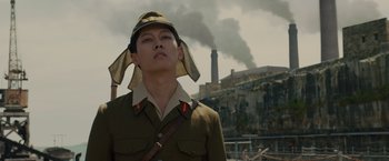 Movie still from “Unbroken” (2014), directed by Angelina Jolie – A man in a military uniform with a hat on his head; Medium shot, Low angle
