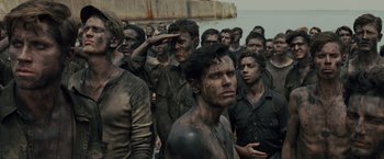 Movie still from “Unbroken” (2014), directed by Angelina Jolie – A large group of men standing next to a body of water; Medium shot, High angle