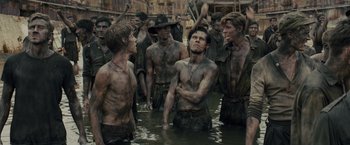 Movie still from “Unbroken” (2014), directed by Angelina Jolie – A group of men standing in a body of water; Medium shot, Over the shoulder angle