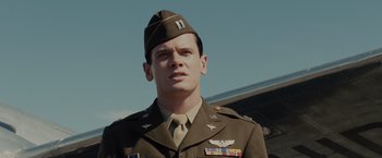 Movie still from “Unbroken” (2014), directed by Angelina Jolie – A man in a military uniform stands in front of an airplane; Close Up shot, Low angle