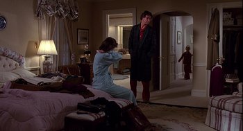 A man and a woman standing in a bedroom