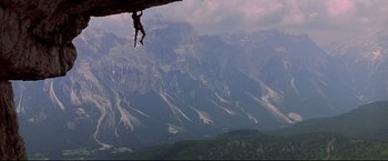 Movie still from “Cliffhanger” (1993), directed by Renny Harlin – A man climbing up the side of a rock wall; Extreme Wide shot, Low angle