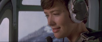 Movie still from “Cliffhanger” (1993), directed by Renny Harlin – A woman wearing a headset and smiling for the camera; Close Up shot, Low angle