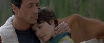 Movie still from “Cliffhanger” (1993), directed by Renny Harlin – A man and a woman embracing each other; Close Up shot, Low angle