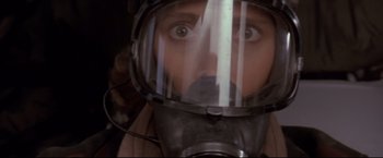 Movie still from “Cliffhanger” (1993), directed by Renny Harlin – A man wearing a gas mask looking at the camera; Close Up shot, Low angle