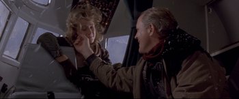 Movie still from “Cliffhanger” (1993), directed by Renny Harlin – A man and a woman are sitting on a plane; Medium shot, Low angle