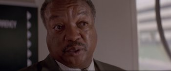 Movie still from “Cliffhanger” (1993), directed by Renny Harlin – An older black man wearing a suit and tie; Close Up shot, Low angle