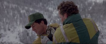 Movie still from “Cliffhanger” (1993), directed by Renny Harlin – A man and a woman holding a dog in their arms; Medium shot, Over the shoulder angle