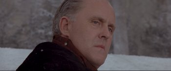 Movie still from “Cliffhanger” (1993), directed by Renny Harlin – An older man in a brown jacket is looking at the camera; Close Up shot, Low angle