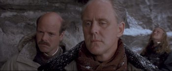 Movie still from “Cliffhanger” (1993), directed by Renny Harlin – A man with a bald head is looking at the camera; Close Up shot, Low angle