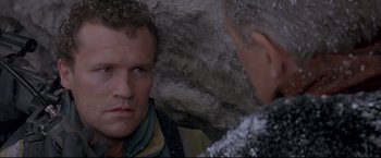 Movie still from “Cliffhanger” (1993), directed by Renny Harlin – A man is looking at another man in a cave; Close Up shot, Over the shoulder angle
