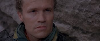 Movie still from “Cliffhanger” (1993), directed by Renny Harlin – A man's face in front of a stone wall; Close Up shot, Low angle