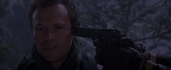 Movie still from “Cliffhanger” (1993), directed by Renny Harlin – A man holding a gun up to his face; Close Up shot, High angle