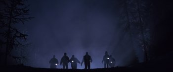 Movie still from “Cliffhanger” (1993), directed by Renny Harlin – A group of people standing on top of a hill at night; Extreme Wide shot, Low angle