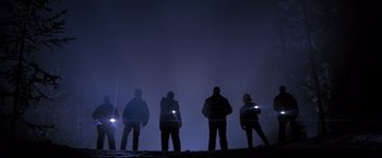 Movie still from “Cliffhanger” (1993), directed by Renny Harlin – A group of people standing on top of a hill at night; Wide shot, Low angle