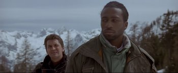 Movie still from “Cliffhanger” (1993), directed by Renny Harlin – Two men standing in front of snow covered mountains; Close Up shot, Low angle