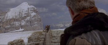 Movie still from “Cliffhanger” (1993), directed by Renny Harlin – A man standing on top of a wooden bridge; Wide shot, Low angle