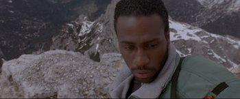 Movie still from “Cliffhanger” (1993), directed by Renny Harlin – A person on top of a mountain; Close Up shot, Overhead angle