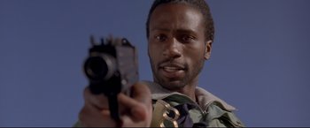 Movie still from “Cliffhanger” (1993), directed by Renny Harlin – A man holding a camera in his hand; Close Up shot, Low angle
