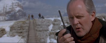 Movie still from “Cliffhanger” (1993), directed by Renny Harlin – A man holding a walkie talkie in his hand; Close Up shot, Low angle