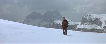 Movie still from “Cliffhanger” (1993), directed by Renny Harlin – A man standing on top of a snow covered slope; Wide shot, Low angle