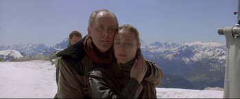 Movie still from “Cliffhanger” (1993), directed by Renny Harlin – A man and a woman hugging on top of a mountain; Close Up shot, Low angle