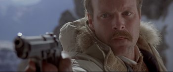 Movie still from “Cliffhanger” (1993), directed by Renny Harlin – A person holding a gun; Close Up shot, Low angle