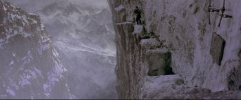 Movie still from “Cliffhanger” (1993), directed by Renny Harlin – A man standing on top of a cliff on top of a mountain; Extreme Wide shot, High angle