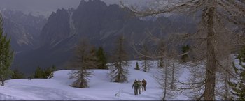 Movie still from “Cliffhanger” (1993), directed by Renny Harlin – A group of skiers on a snowy slope near a mountain range; Extreme Wide shot, High angle