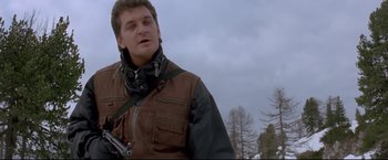 Movie still from “Cliffhanger” (1993), directed by Renny Harlin – A man in a brown jacket is holding a gun; Close Up shot, Low angle