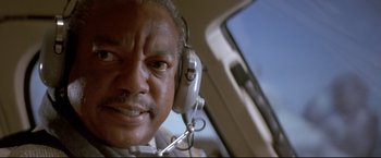 Movie still from “Cliffhanger” (1993), directed by Renny Harlin – An older man wearing headphones in an airplane cockpit; Close Up shot, Low angle
