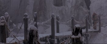 Movie still from “Cliffhanger” (1993), directed by Renny Harlin – A bridge with snow on the ground next to a mountain; Extreme Wide shot, Low angle