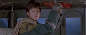 Movie still from “Cliffhanger” (1993), directed by Renny Harlin – A woman holding onto a metal object while wearing a jacket; Close Up shot, Low angle