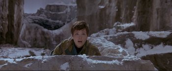 Movie still from “Cliffhanger” (1993), directed by Renny Harlin – A young boy is looking over a ledge in the snow; Medium shot, High angle