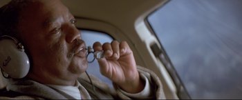 Movie still from “Cliffhanger” (1993), directed by Renny Harlin – A man holding a pair of glasses in a car; Extreme Close Up shot, Low angle