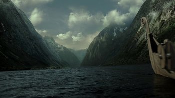 Movie still from “Vikings” (2013), created by Michael Hirst – A body of water surrounded by mountains under a cloudy sky; Extreme Wide shot, High angle