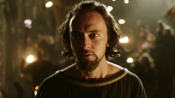 Movie still from “Vikings” (2013), created by Michael Hirst – A man with long hair and a beard stares at the camera; Close Up shot, Low angle