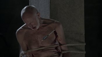 Movie still from “Vikings” (2013), created by Michael Hirst – A bald man with blood on his face and chest; Medium shot, Overhead angle